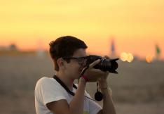 Jeune en train de prendre une photo au coucher du soleil