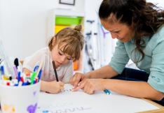 enfant dessinant devant une psychologue.