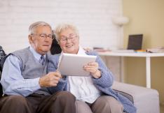 COUPLE DE SENIORS UTILISANT UNE TABLETTE NUMERIQUE