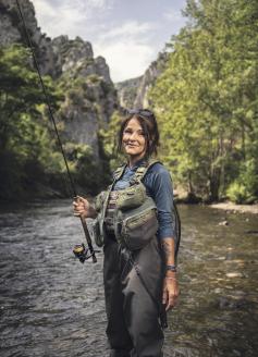 Lenka Stary tient une canne à pêche dans un fleuve de l'Aude