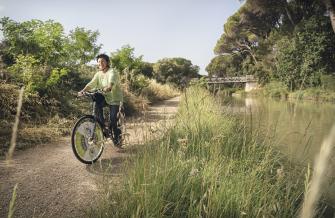 Femme cycliste le long du canal du midi, au somail, dans l'Aude