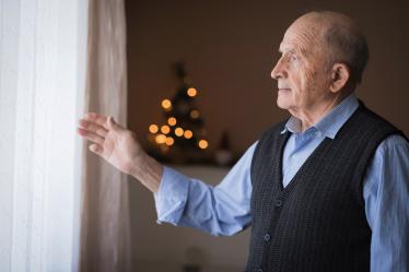 homme âgé seul regardant par la fenêtre