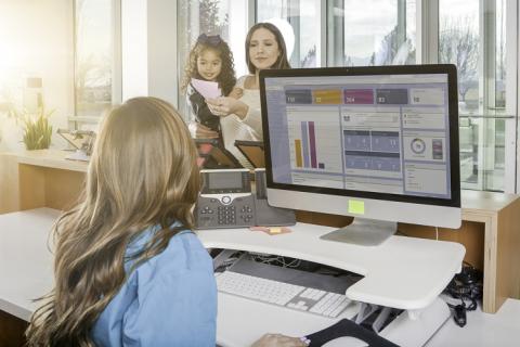jeune femme accueillant une femme avec son enfant, dans un lieu d'accueil du public