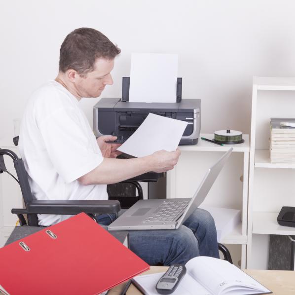 un homme en fauteuil roulant fait un point sur ses dossiers