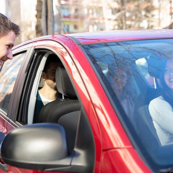 Jeune homme faisant du covoiturage avec une conductrice