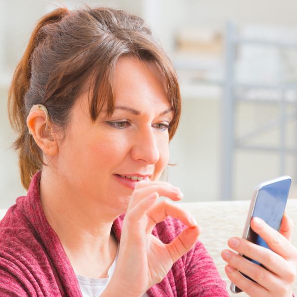 Personne sourde communiquant en langage des signes avec son téléphone