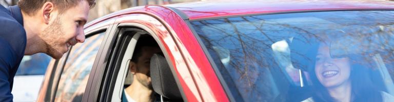 Jeune homme faisant du covoiturage avec une conductrice