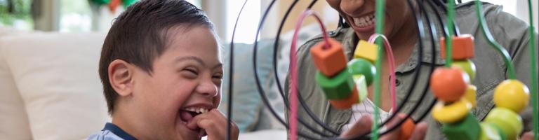 ENFANT HANDICAPÉ QUI JOUE AVEC UN  ADULTE