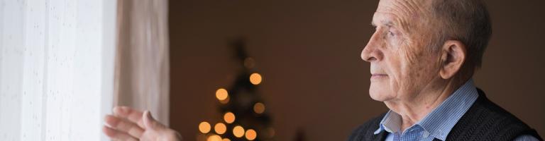 homme âgé seul regardant par la fenêtre