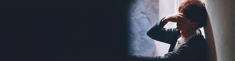 Adolescent se prenant les mains dans la tete.