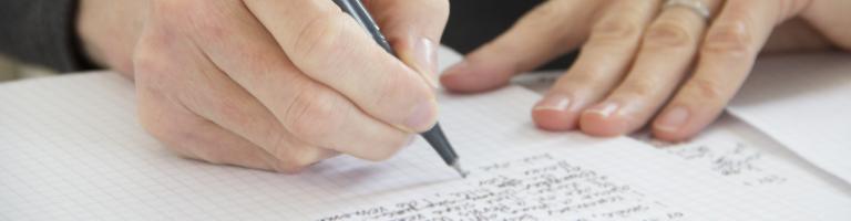 mains de femme écrivant sur un cahier