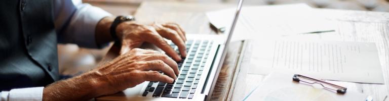 Senior remplissant le formulaire APA en ligne depuis un ordinateur