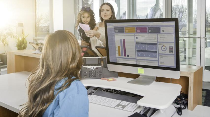 jeune femme accueillant une femme avec son enfant, dans un lieu d'accueil du public