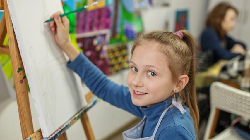 Jeune fille en train de dessiner devant un chevalet