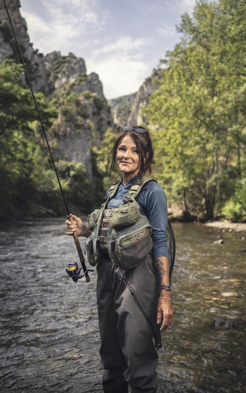 Lenka Stary tient une canne à pêche dans un fleuve de l'Aude